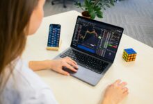 a woman sitting at a table using a laptop computer