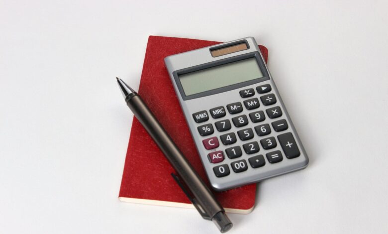 black and silver calculator beside black pen