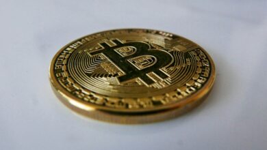 a gold bit coin sitting on top of a white table