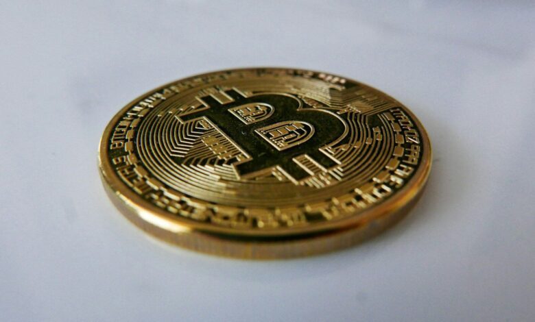 a gold bit coin sitting on top of a white table