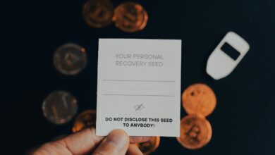 a person holding a business card in front of a pile of coins