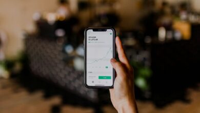 person holding black iPhone displaying stock exchange