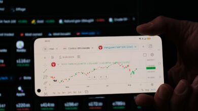 A person holding a business card in front of a computer screen