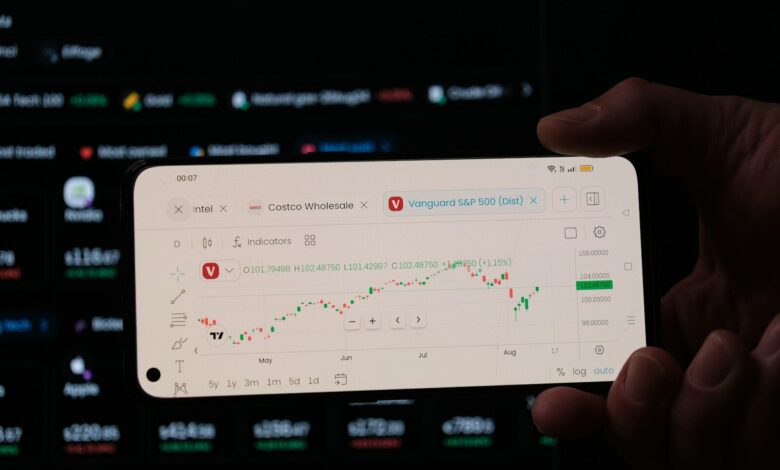 A person holding a business card in front of a computer screen