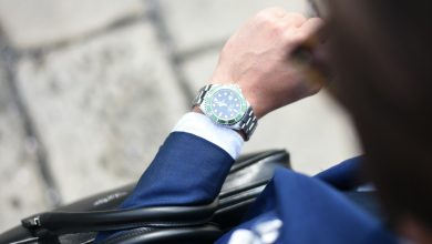 person looking at silver-colored analog watch