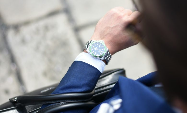 person looking at silver-colored analog watch