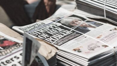 shallow focus photography of piles of newspapers